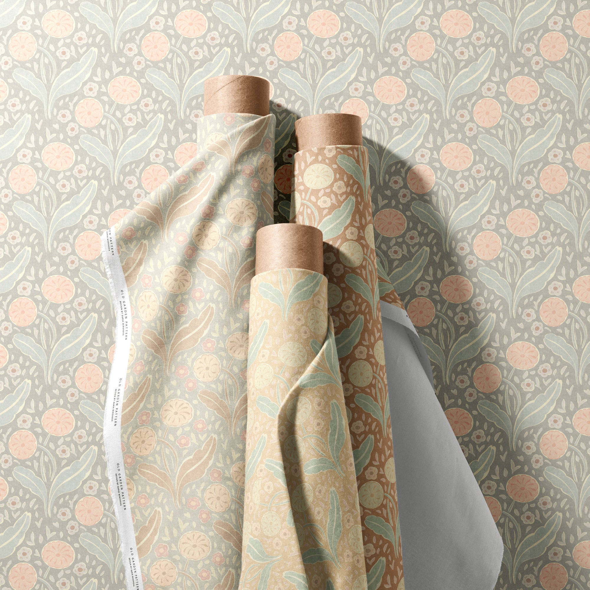 Rolls of fabric with floral patterns on a floral wallpaper background