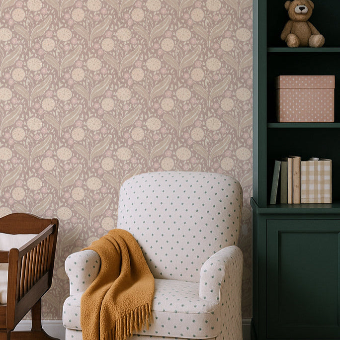 White armchair with a mustard yellow blanket in a room with floral wallpaper and a green bookshelf.