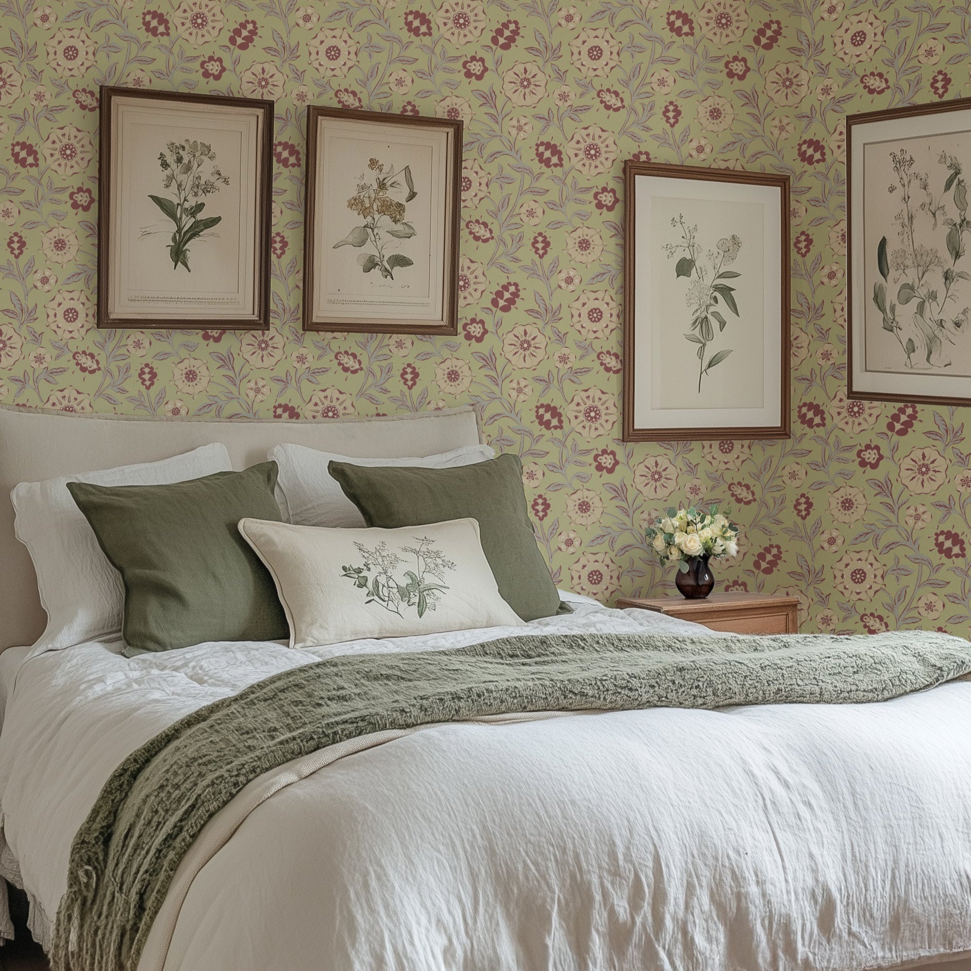 Bedroom with floral wallpaper, framed botanical prints, and a vase with flowers on a nightstand.
