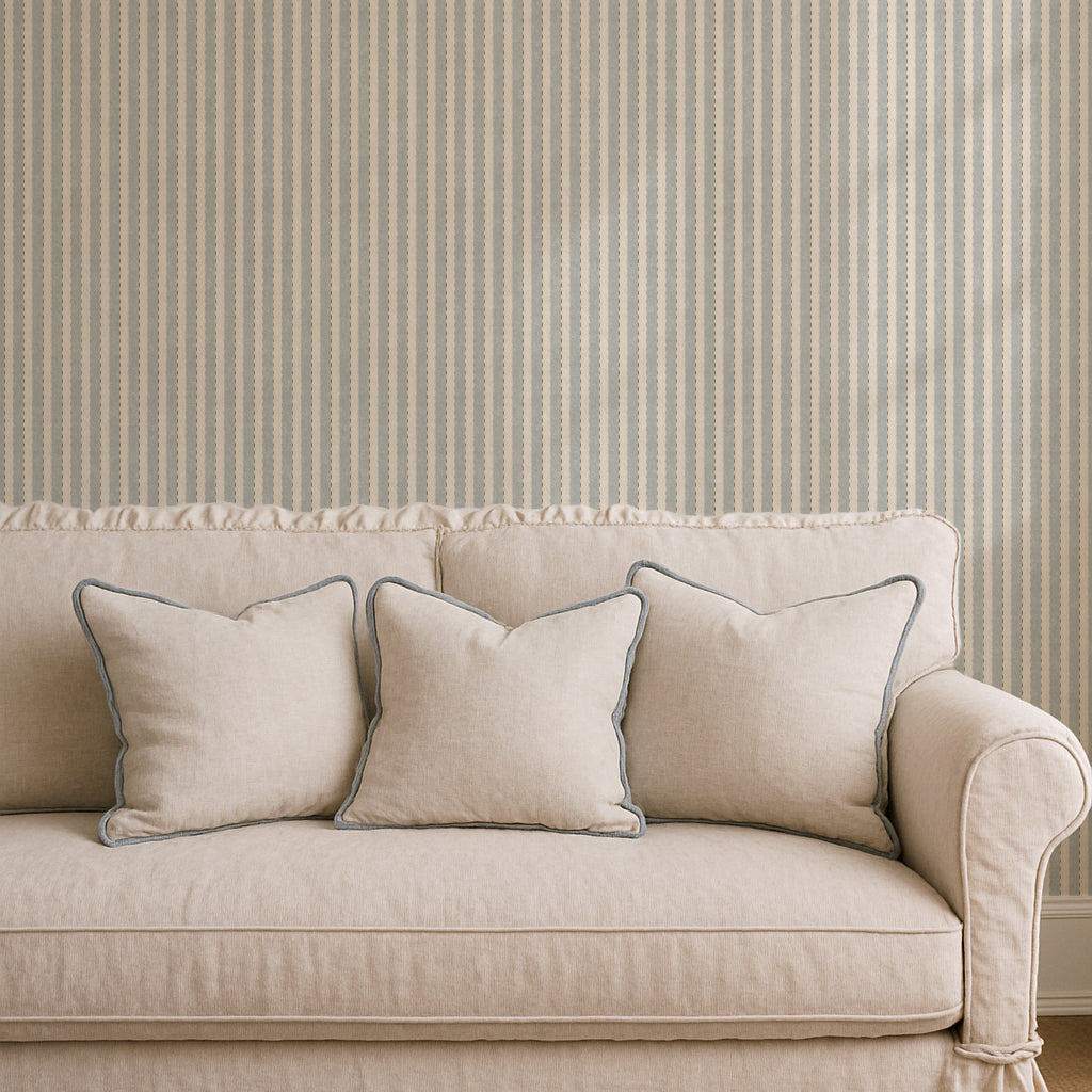Beige sofa with decorative pillows against a striped wall.
