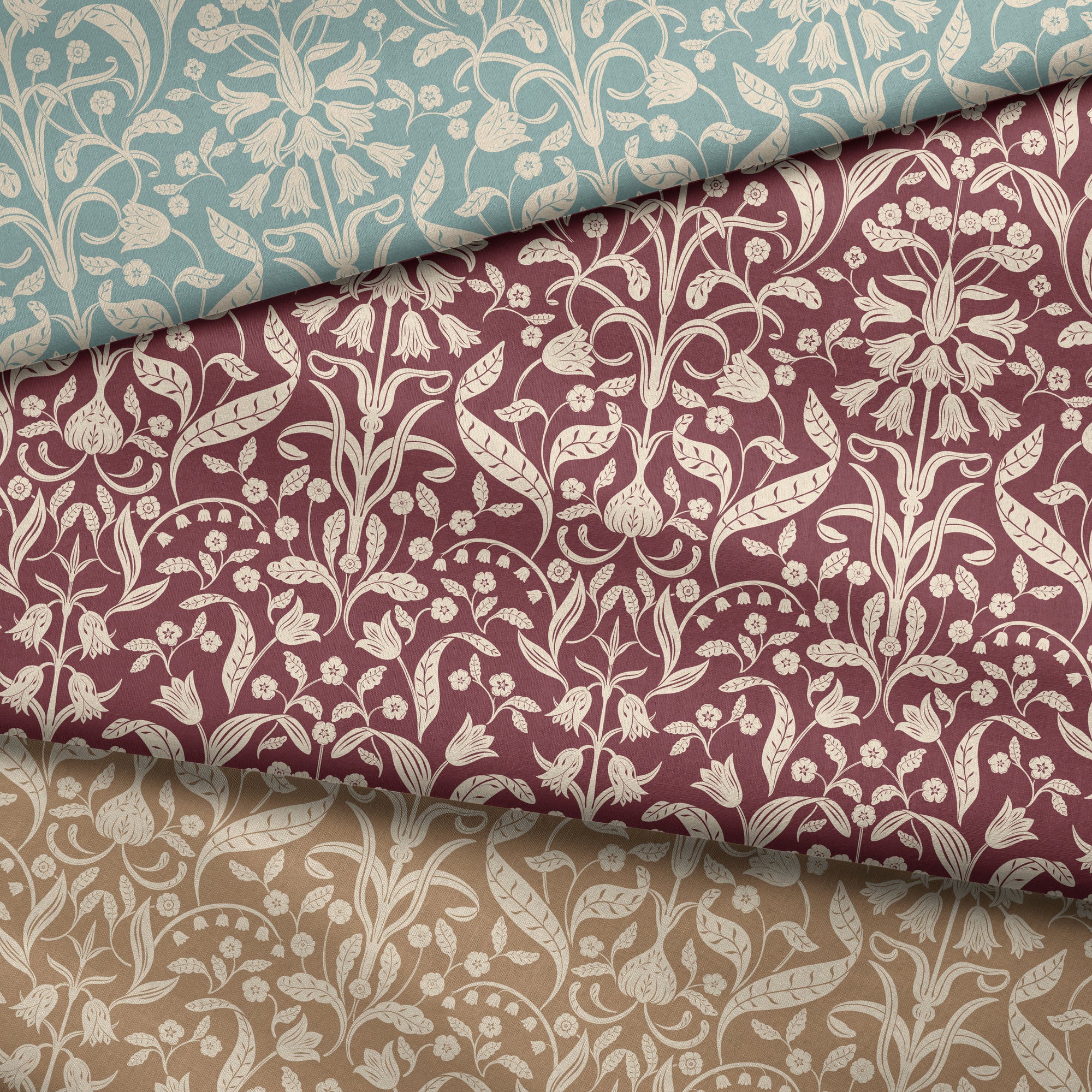 Three rolls of fabric with floral patterns in teal, red, and beige.